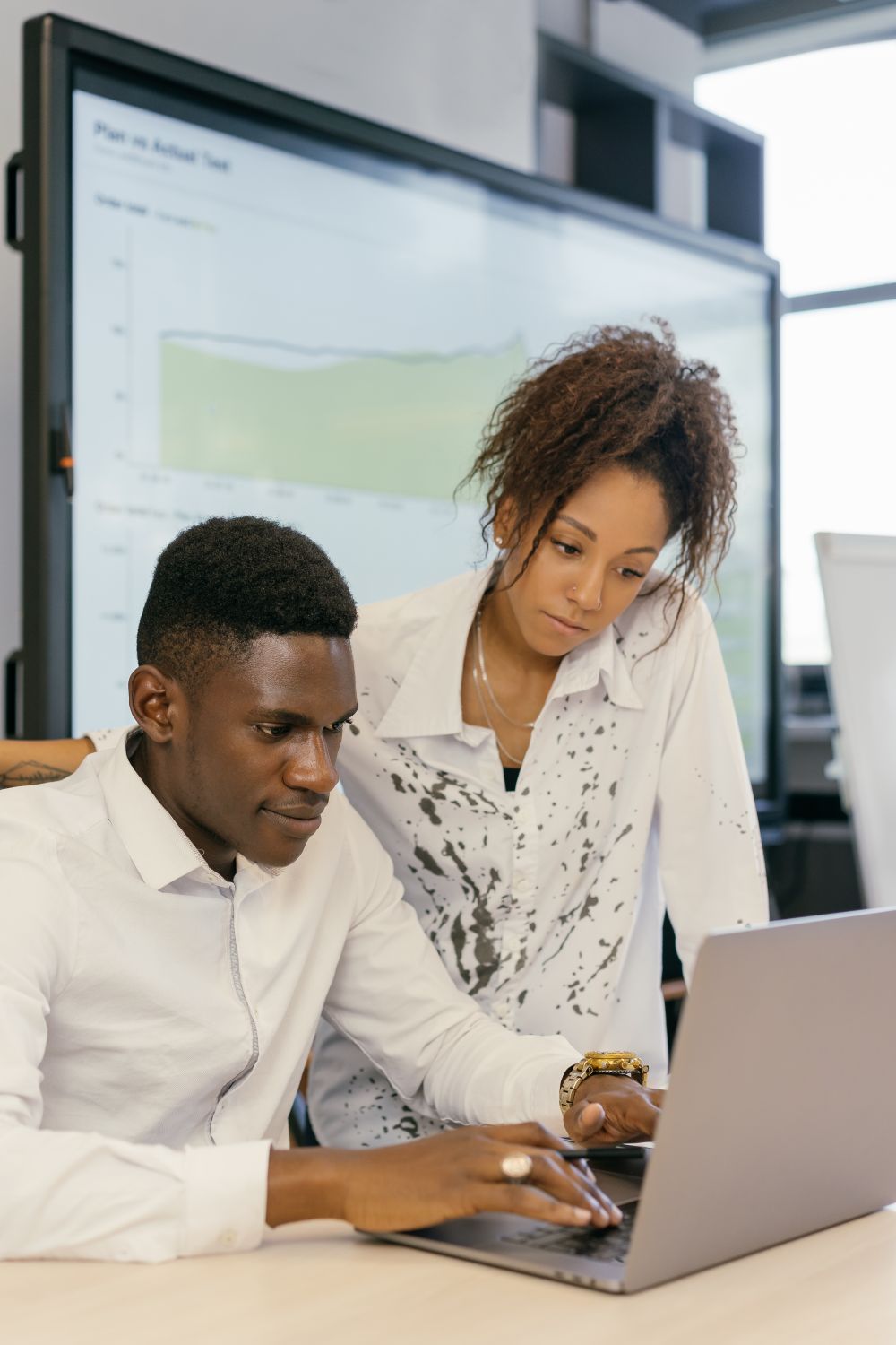 Two colleagues collaborating on a laptop